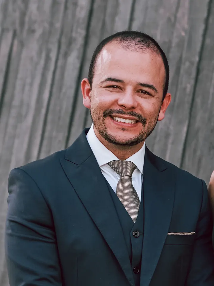 Dr. André de Sá, sorrindo, de terno escuro